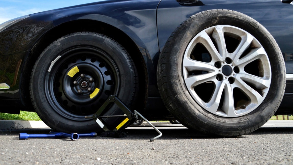 A car mounted with temporary donut spare tire.