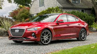 2021 Genesis G70 in red parked in front of a home.
