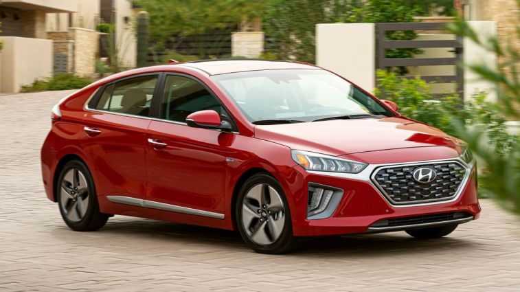 2021 Hyundai Ioniq Hybrid in red driving around homes.
