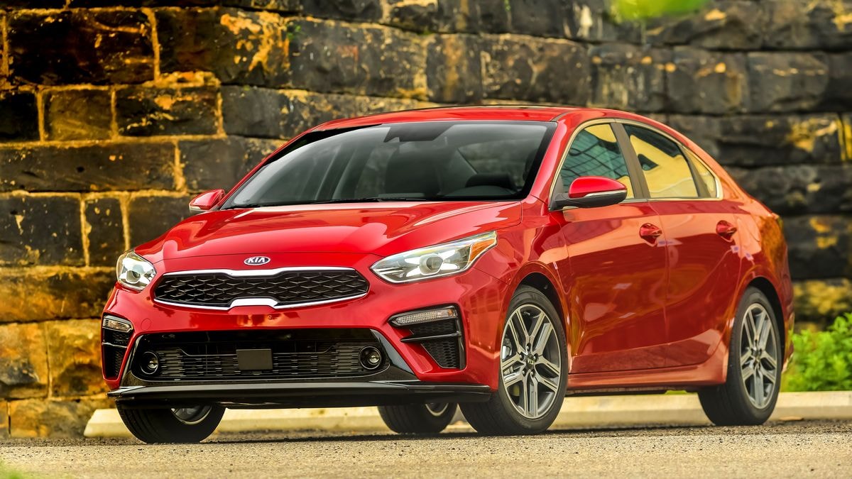 2021 Kia Forte in red parked next to a brick wall.