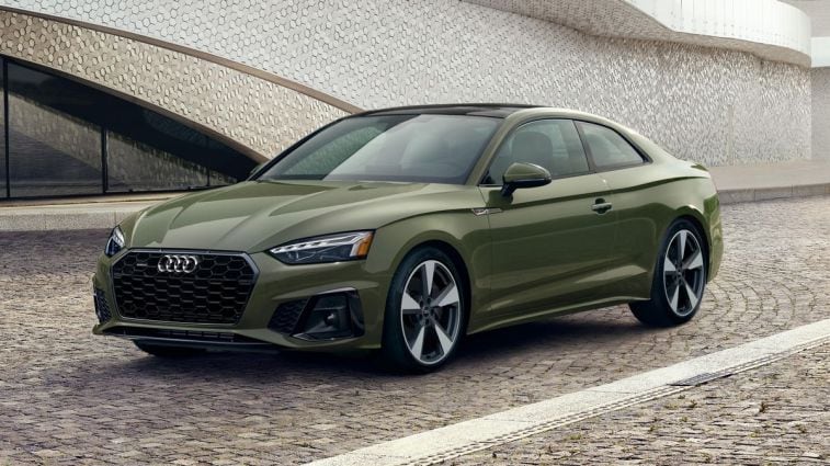 2024 Audi A5 Coupe in green parked near a scaly building.