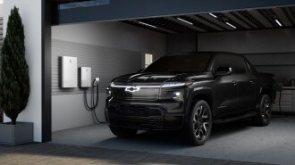 A GM rendering showing a 2024 Chevrolet Silverado EV passing power to a home through a vehicle-to-grid system.