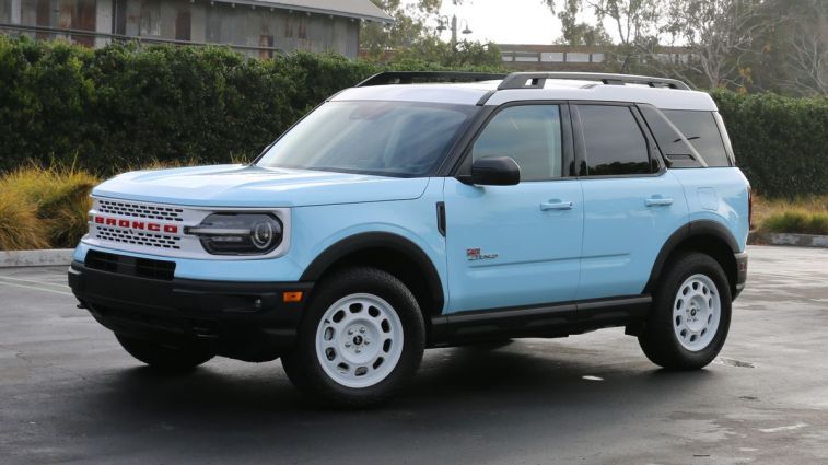 2024 Ford Bronco Sport Heritage Edition with a hedge and metal building in the background.