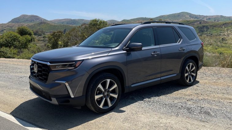 2024 Honda Pilot Elite in grey with hills in the background.