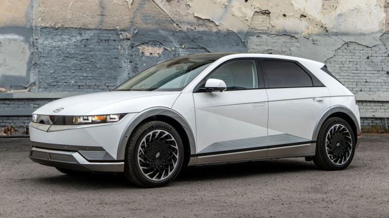 2024 Hyundai Ioniq 5 in white with a peeling brick wall in the background.
