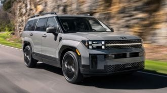 2024 Hyundai Santa Fe in grey driving on a road.