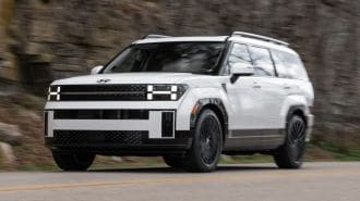 2024 Hyundai Santa Fe in white driving on a road.