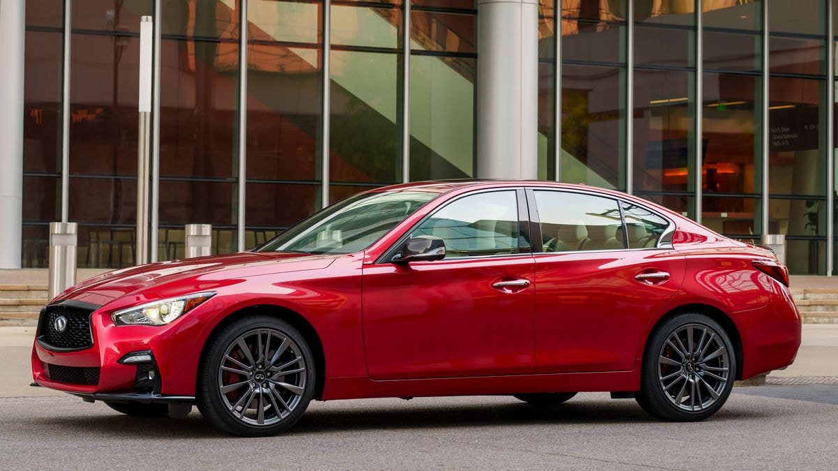 2024 Infiniti Q50 S in red parked in front of an office building.