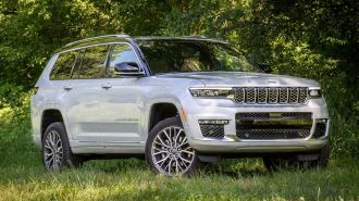 2024 Jeep Grand Cherokee L Summit Reserve parked amongst trees and grass.