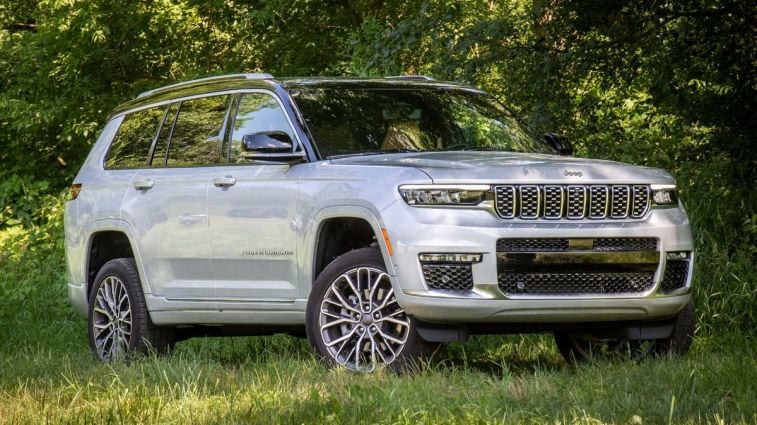 2024 Jeep Grand Cherokee L Summit Reserve parked amongst trees and grass.
