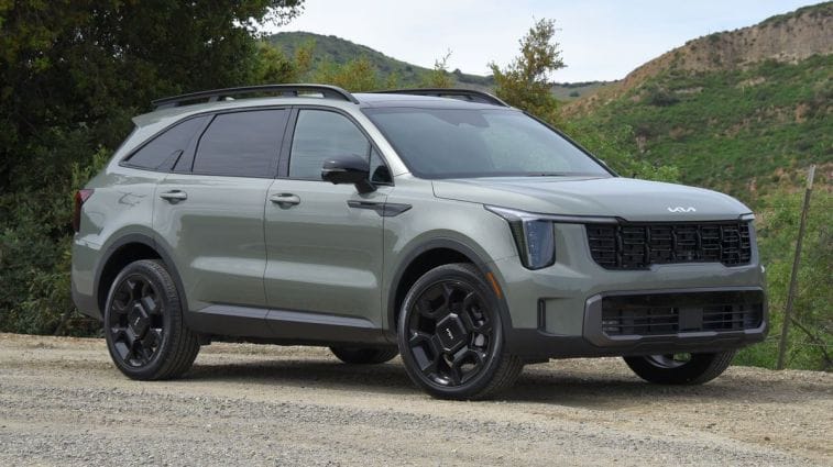 2024 Kia ​​Sorento X-Line in jungle green with hills and trees in the background.