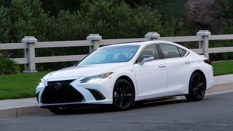 2024 Lexus ES 300h in white with a fence in the background.