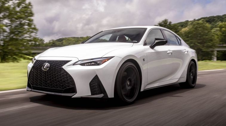 2024 لكزس IS 350 F-Sport باللون الأبيض أثناء قيادتها على الطريق.