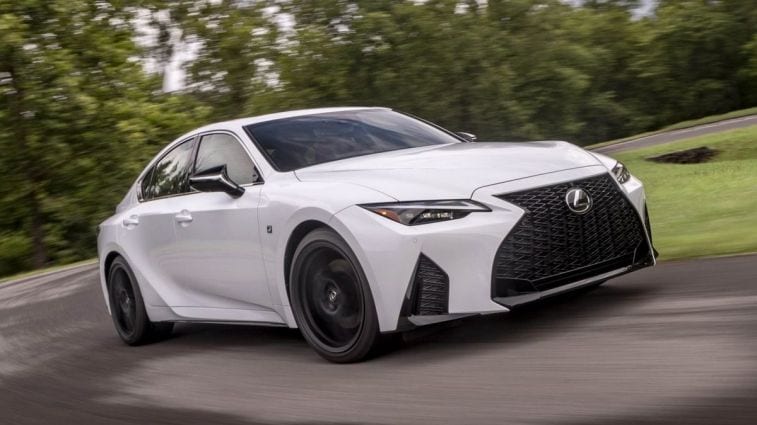 2024 Lexus IS 350 F-Sport in white driving around a corner.