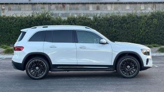 2024 Mercedes-Benz GLB 250 in white with a metal barn in the background.