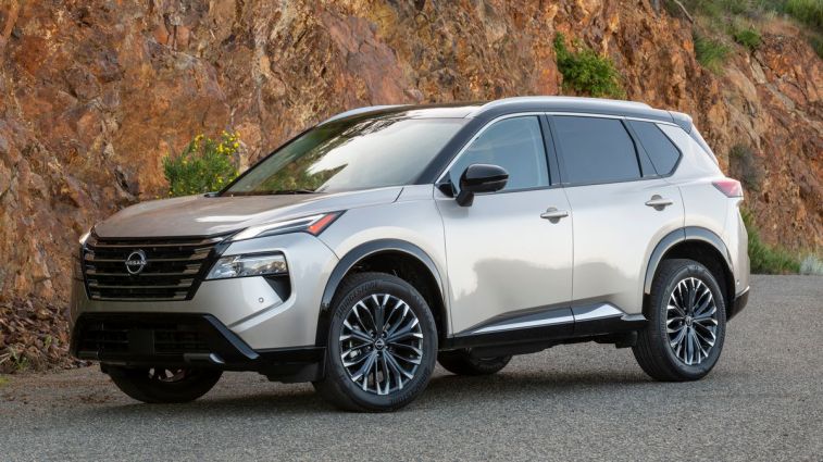 2024 Nissan Rogue Platinum with a rock wall in the background.