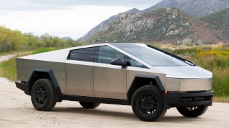 2024 Tesla Cybertruck on a dirt road with hills in the background.