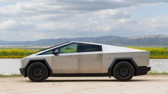 2024 Tesla Cybertruck with a lake and hills in the background.