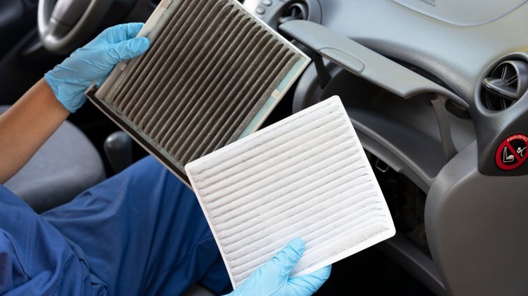 A car technician replacing cabin air filter.
