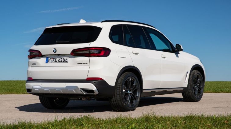 سيارة BMW X5 PHEV موديل 2021 باللون الأبيض مع سماء زرقاء في الخلفية.