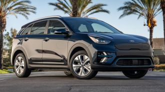 2021 Kia Niro EV in black with palm trees in the background.
