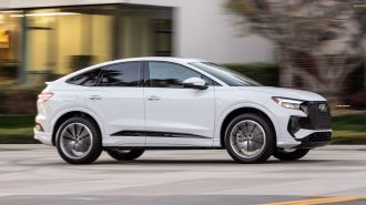 2024 Audi Q4 Sportback e-tron in white driving on a street.