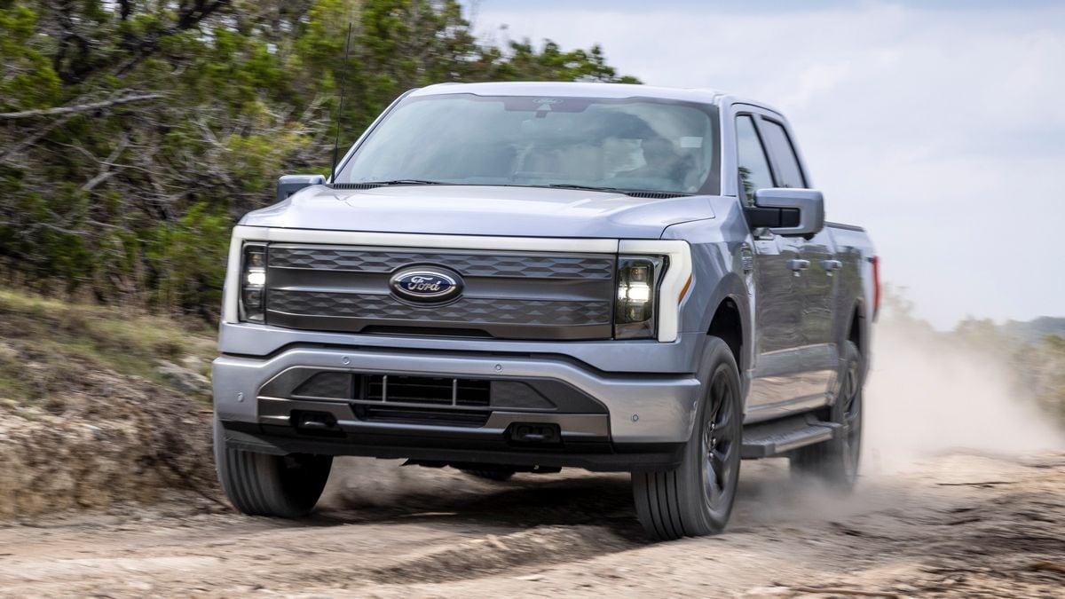 2024 F-150 Lightning Lariat driving on a dirt road.