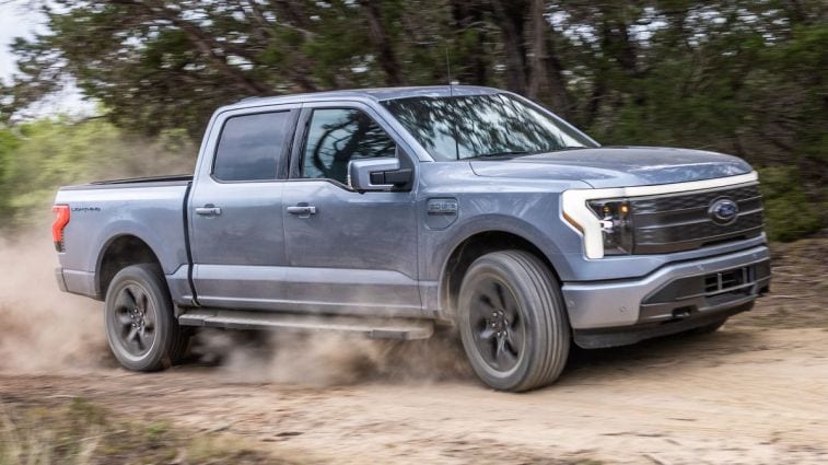 2024 F-150 Lightning Lariat driving on a dirt road.