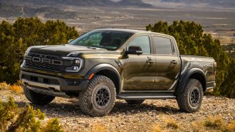 2024 Ford Ranger Raptor parked on a rocky hill with a valley in the background.