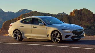 2024 Genesis G70 at sunset with rock formations in the background.