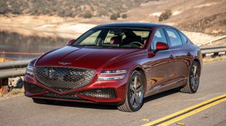 2024 Genesis G80 in red parked on a highway.