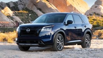 2024 Nissan Pathfinder in blue with rock formations in the background.