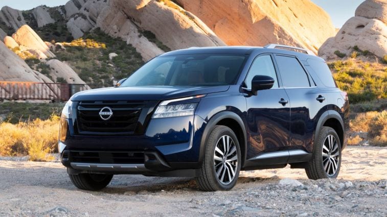 2024 Nissan Pathfinder in blue with rock formations in the background.