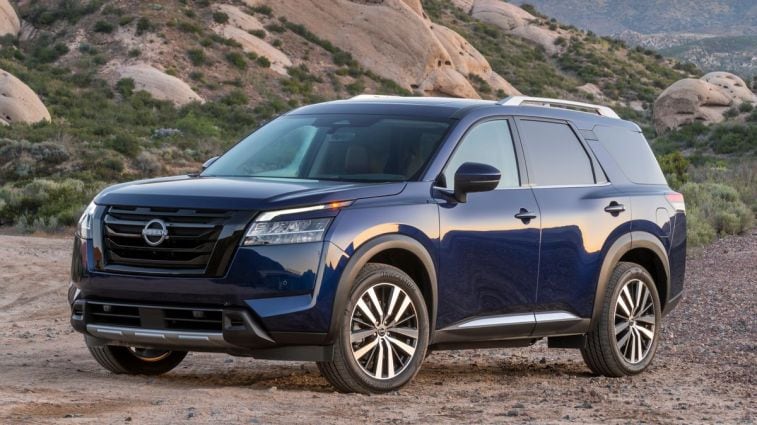 2024 Nissan Pathfinder in blue with rock formations in the background.