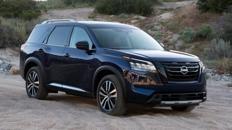 2024 Nissan Pathfinder in blue sitting in the sand.