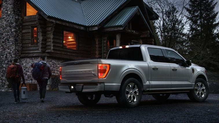 2021 Ford F-150 Platinum in silver near a cabin at night.