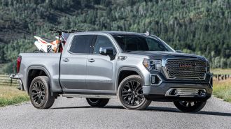 2021 GMC Sierra Denali with pine trees in the background.