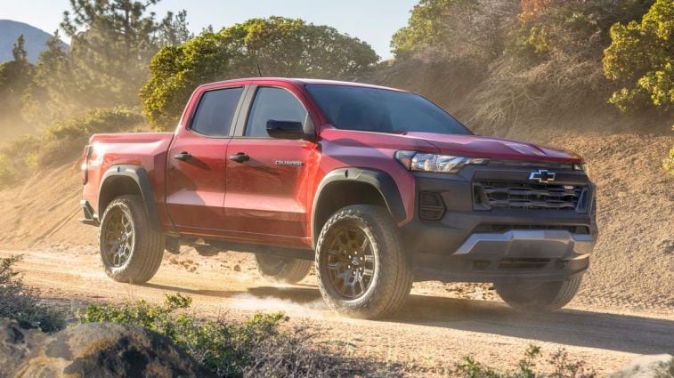 2024 Chevrolet Colorado Trail Boss driving down a dirt road during golden hour.