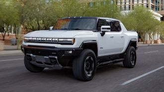 2024 GMC HUMMER EV Edition 1 Pickup driving on a city road.