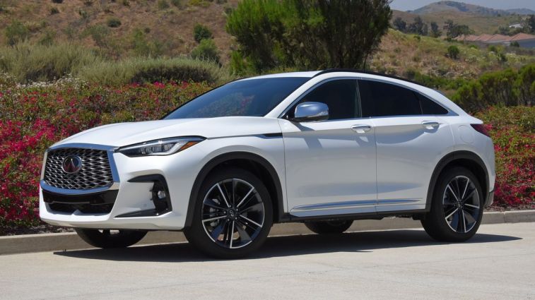 2024 Infiniti QX55 in Radiant White with shrubs in the background.