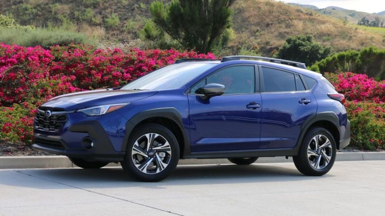 2024 Subaru Crosstrek with plants and hills in the background.