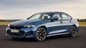2025 BMW 3 Series parked near a grass field.