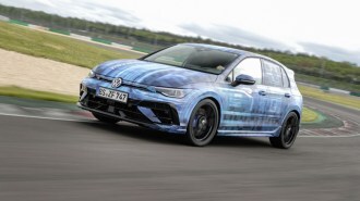 A teaser photo showing the 2025 Volkswagen Golf R seen from a front quarter angle, wrapped in camouflage