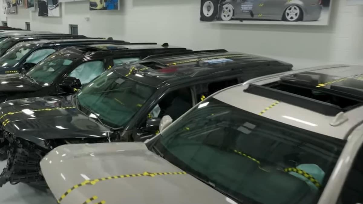 A group of full-size SUVs after crash testing by the Insurance Institute for Highway Safety
