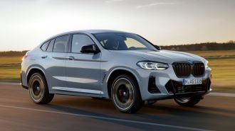 2024 BMW X4 in Brooklyn Grey driving on a road.