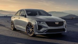 2024 Cadillac CT4-V in Argent Silver Metallic parked at a turnout on a mountain road.