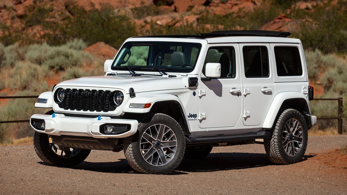 2024 Jeep Wrangler High Altitude 4xe parked on gravel near a trail.