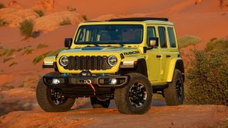 2024 Jeep Wrangler Rubicon X 4xe parked on a rock at sunset.