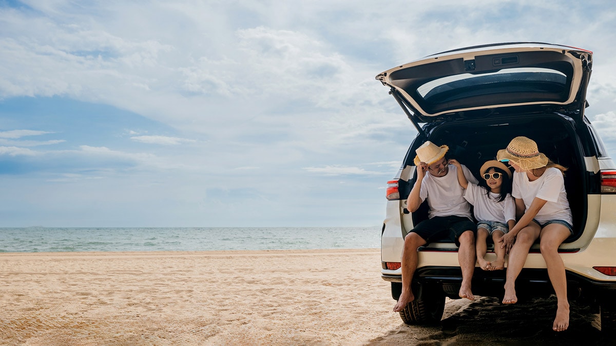 Car on the beach with family.