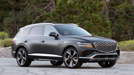 2025 Genesis GV80 3.5T in Storr Green with trees in the background.